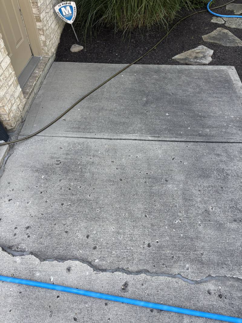 Mid-wash: the line between cleaned and untouched concrete