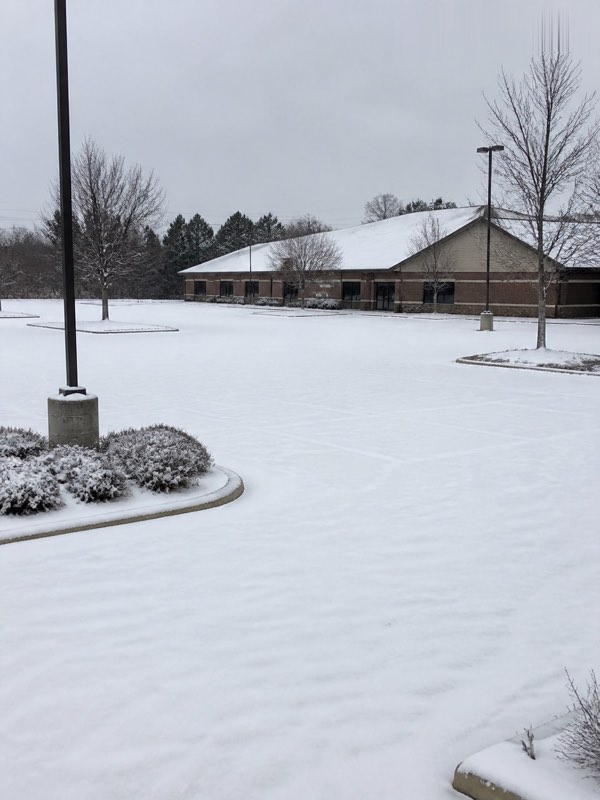 Illustration — snow-covered commercial parking lot before plowing