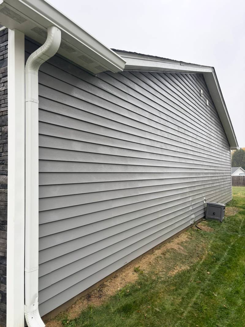 The same gray siding clean after soft washing