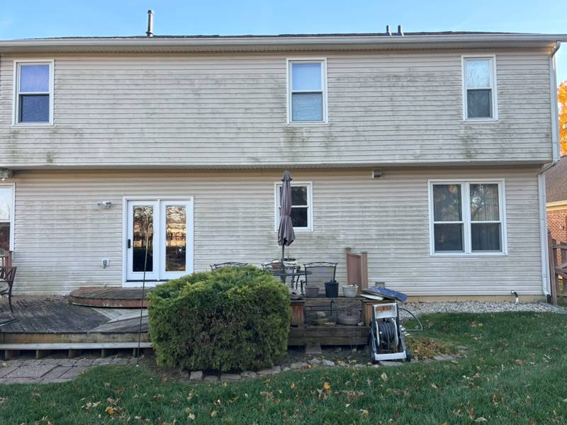 Two-story vinyl siding streaked with algae before soft washing